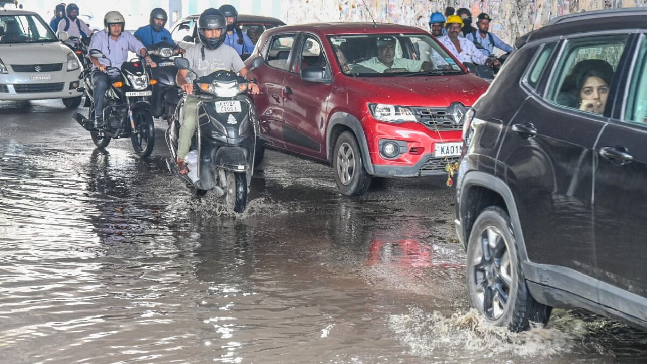 Motorists and cars wade through rainwater at the railway underpass, Okalipuram, in Bengaluru on Monday. Credit: DH Photo/S K Dinesh