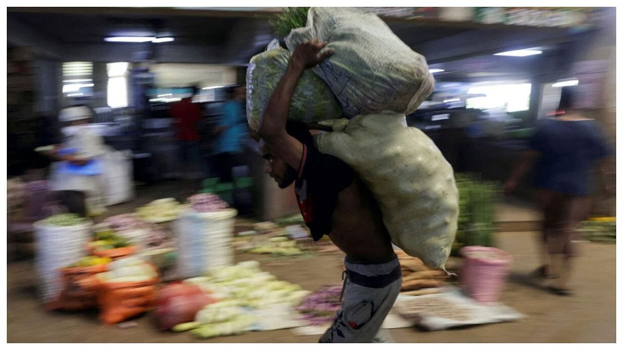 A worker carries sacks of vegetables at a wholesale market in Colombo, Sri Lanka. Credit: Reuters File Photo