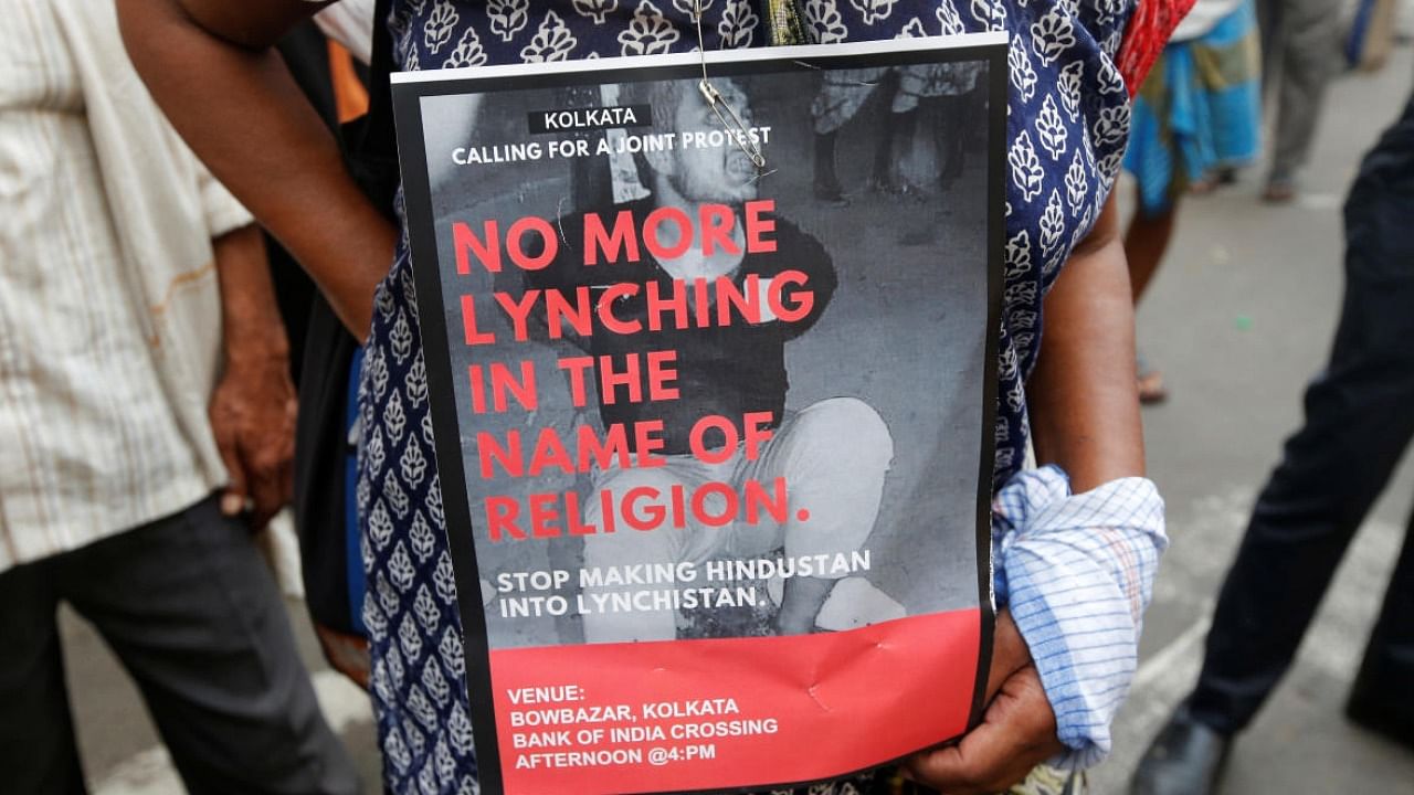 A woman holds a placard during a protest against the lynching of Tabrez Ansari by a Hindu mob in Kolkata. credit: Reuters File Photo