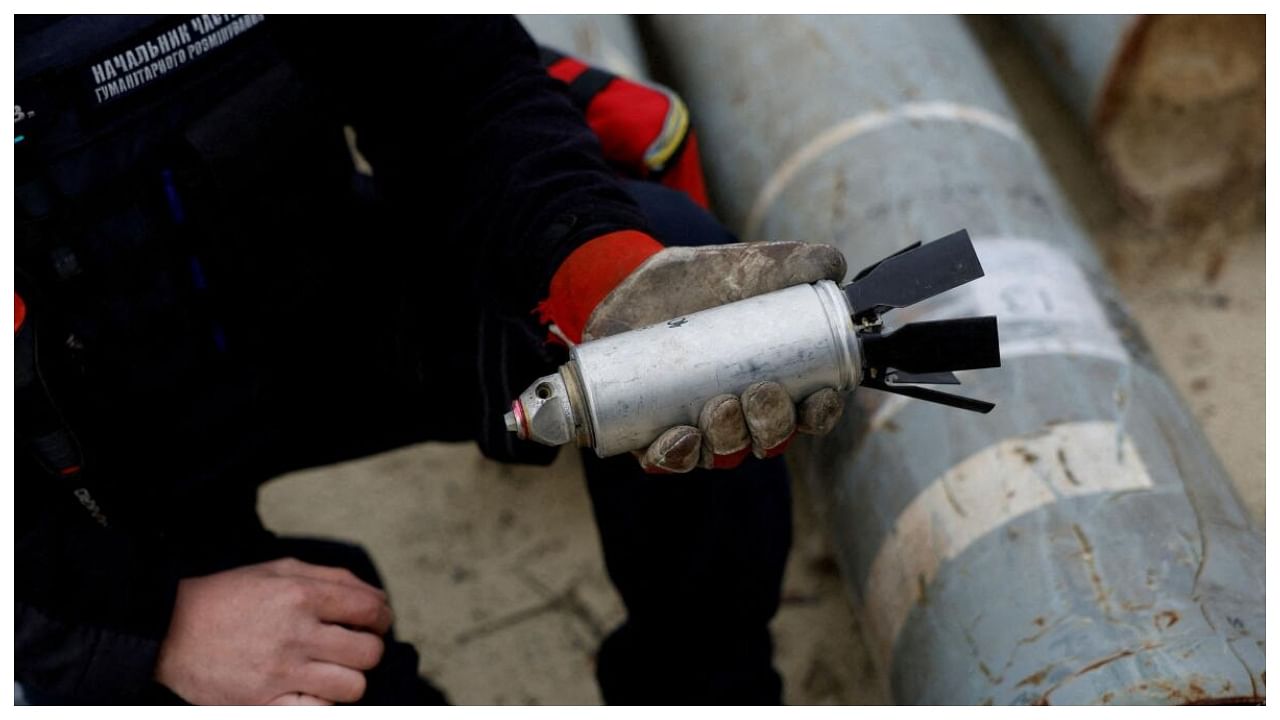 Ukrainian military serviceman Igor Ovcharruck holds a defused cluster bomb from an MSLR missile. Credit: Reuters File Photo