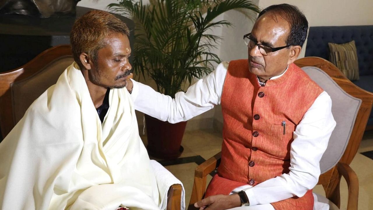 MP Chief Minister Shivraj Singh Chouhan (right) with Dashmat Rawat (left) the Sidhi urination case victim. Credit: PTI Photo 