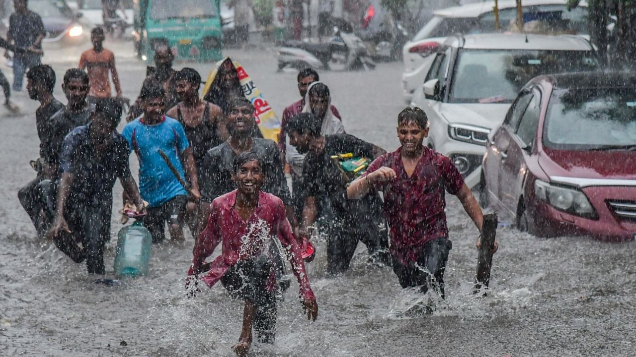 Young boys have fun on a waterlogged road after monsoon rains, in New Delhi. Credit: PTI Photo