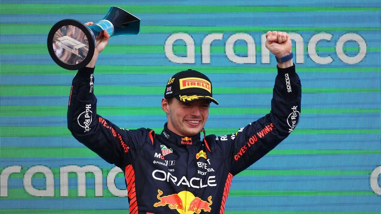 Red Bull's Max Verstappen celebrates with a trophy on the podium after winning the race. Credit: Reuters Photo