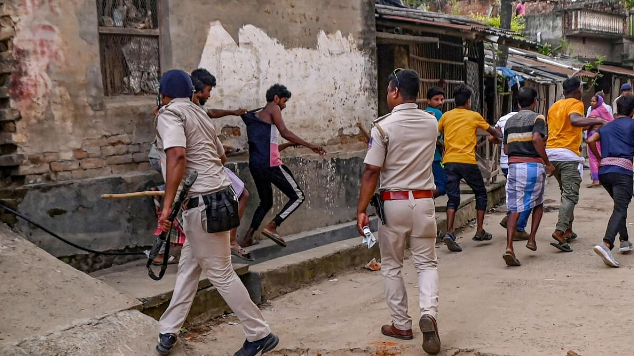 Police personnel baton charge after a clash between rival political groups during panchyat elections, at Nagaria village in Malda district of West Bengal. Credit: PTI Photo