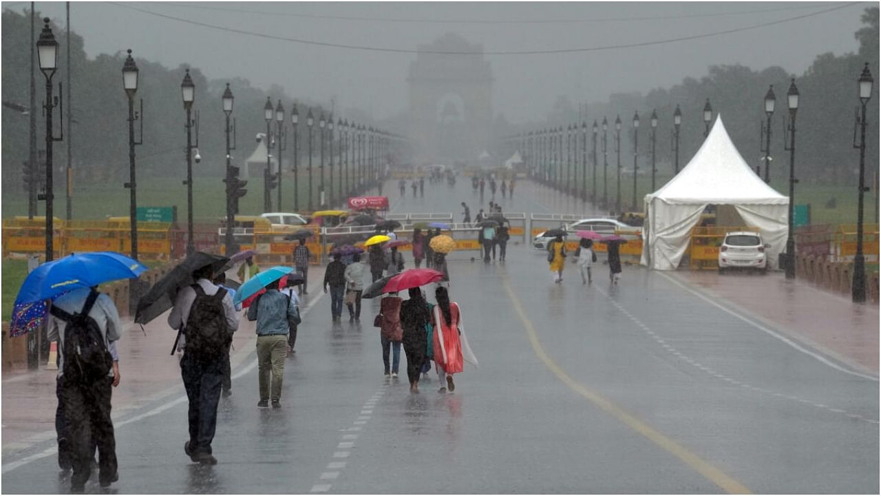 New Delhi: Younf women walk amid monsoon rains, on Kartavya Path in New Delhi, Monday, July 10, 2023. Credit: PTI Photo