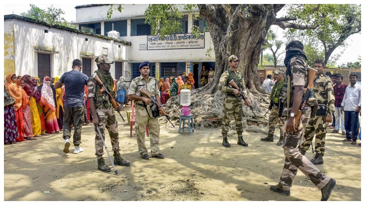 Security personnel stand guard at a polling booth during Panchayat repolls, in Murshidabad district, Monday, July 10, 2023. Credit: PTI Photo