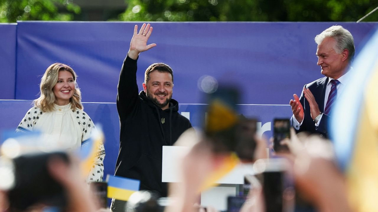 Ukrainian President Volodymyr Zelenskyy, his wife Olena Zelenska, and Lithuanian President Gitanas Nauseda attend a ceremony during which a Ukrainian flag from the frontline of the war with Russia is delivered by activists, on the sidelines of a NATO leaders summit in Vilnius, Lithuania July 11, 2023. Credit: Reuters Photo