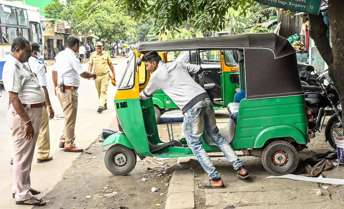 An auto driver removes his vehicle parked on a footpath at Dr Vishnuvardhan Road, Banashankari. DH PHOTO/Prashanth H G