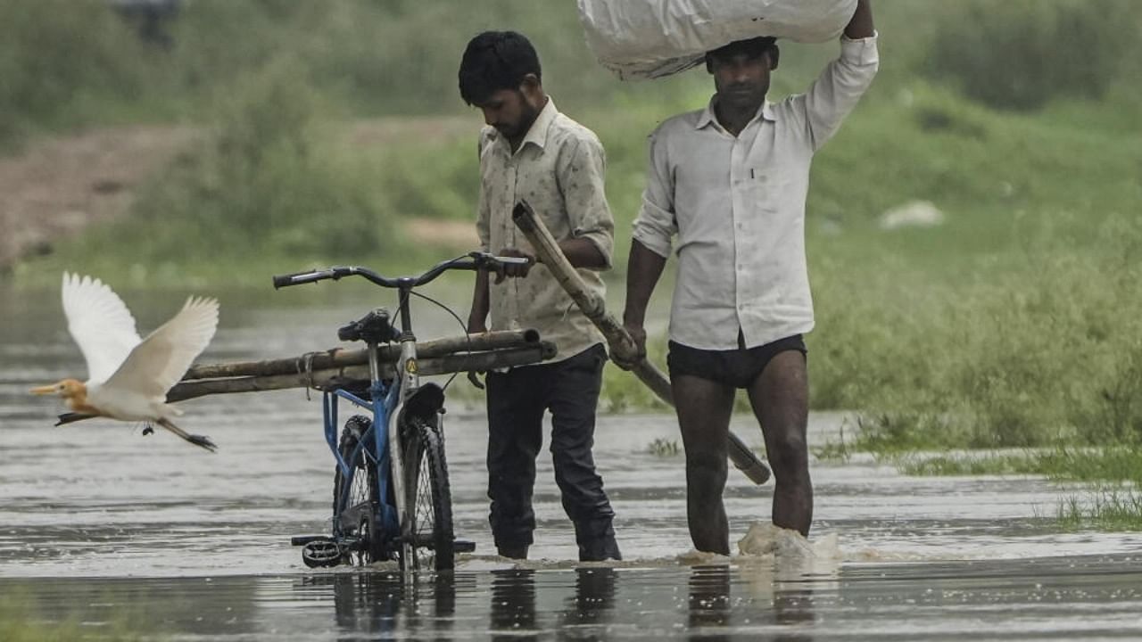 People shift from a flooded area near the Yamuna river, in New Delhi, Tuesday, July 11, 2023. Credit: PTI Photo