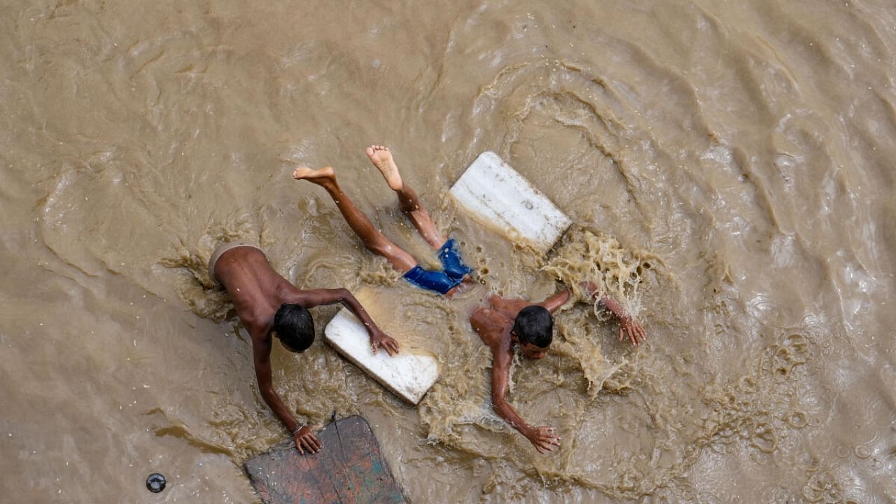 View of children playing in the waters as Delhi floods. Credit: PTI Photo