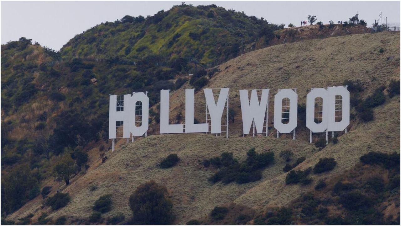 People stand above the Hollywood sign under a cloudy sky in Los Angeles, California, U.S., May 31, 2023. Credit: Reuters Photo