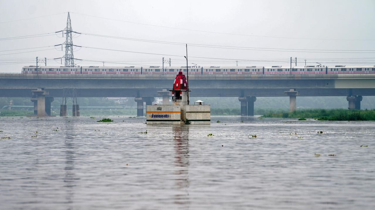 Delhi Metro train passes above Yamuna river after heavy monsoon rains, in New Delhi, Monday, July 10, 2023. Credit: PTI Photo