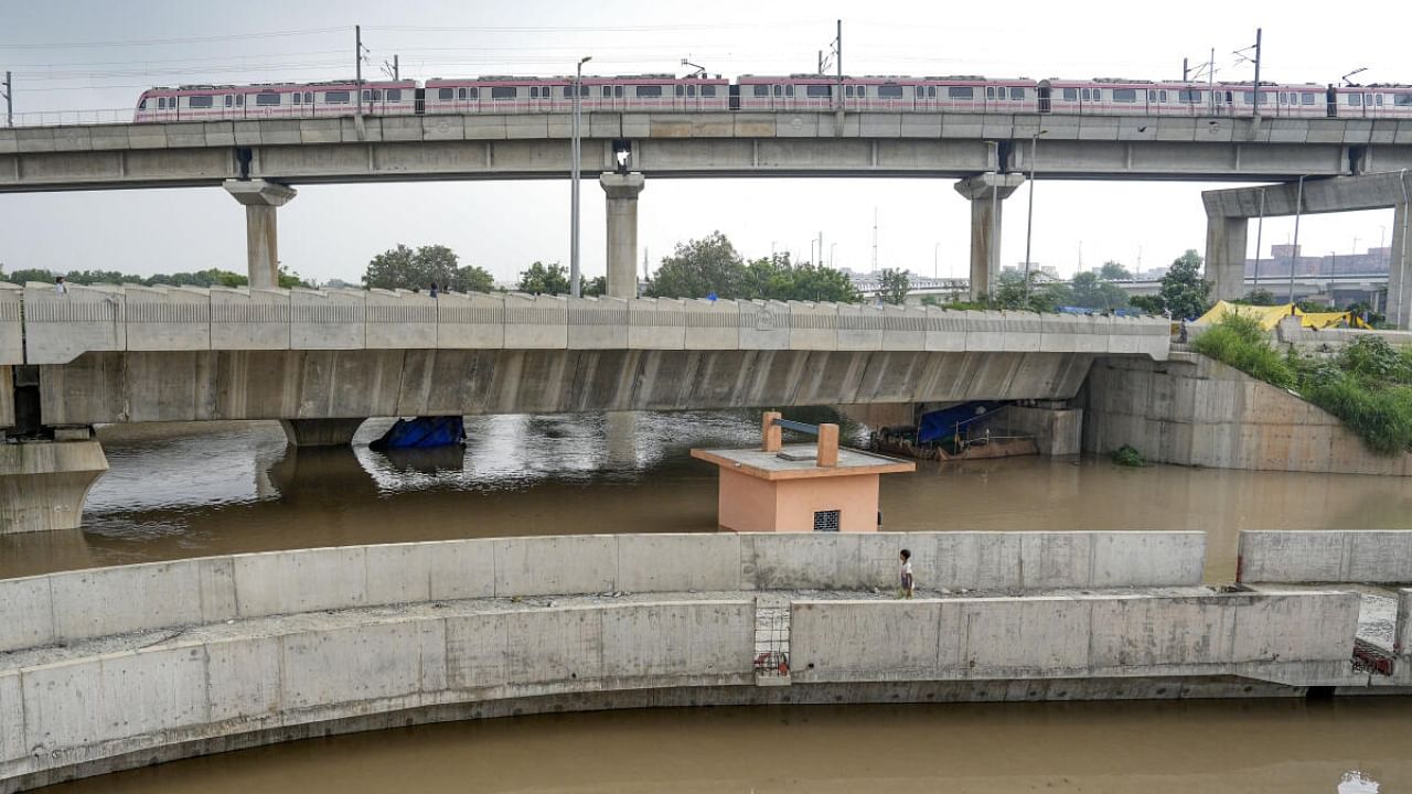  A Delhi Metro train passes above the floodwaters of the swollen Yamuna river at Mayur Vihar, in New Delhi, Wednesday, July 12, 2023. Credit: PTI Photo