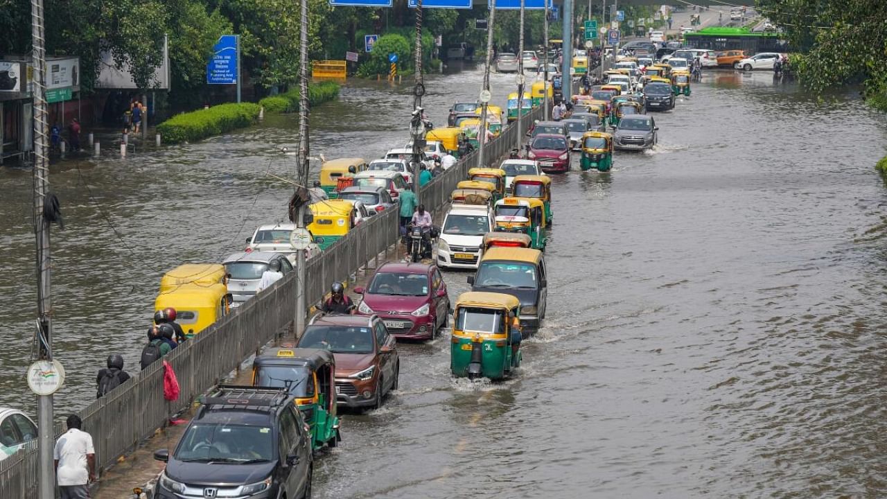 Commuters move through the floodwaters of the swollen Yamuna river, at ITO, in New Delhi, Sunday, July 16, 2023. Credit: PTI Photo