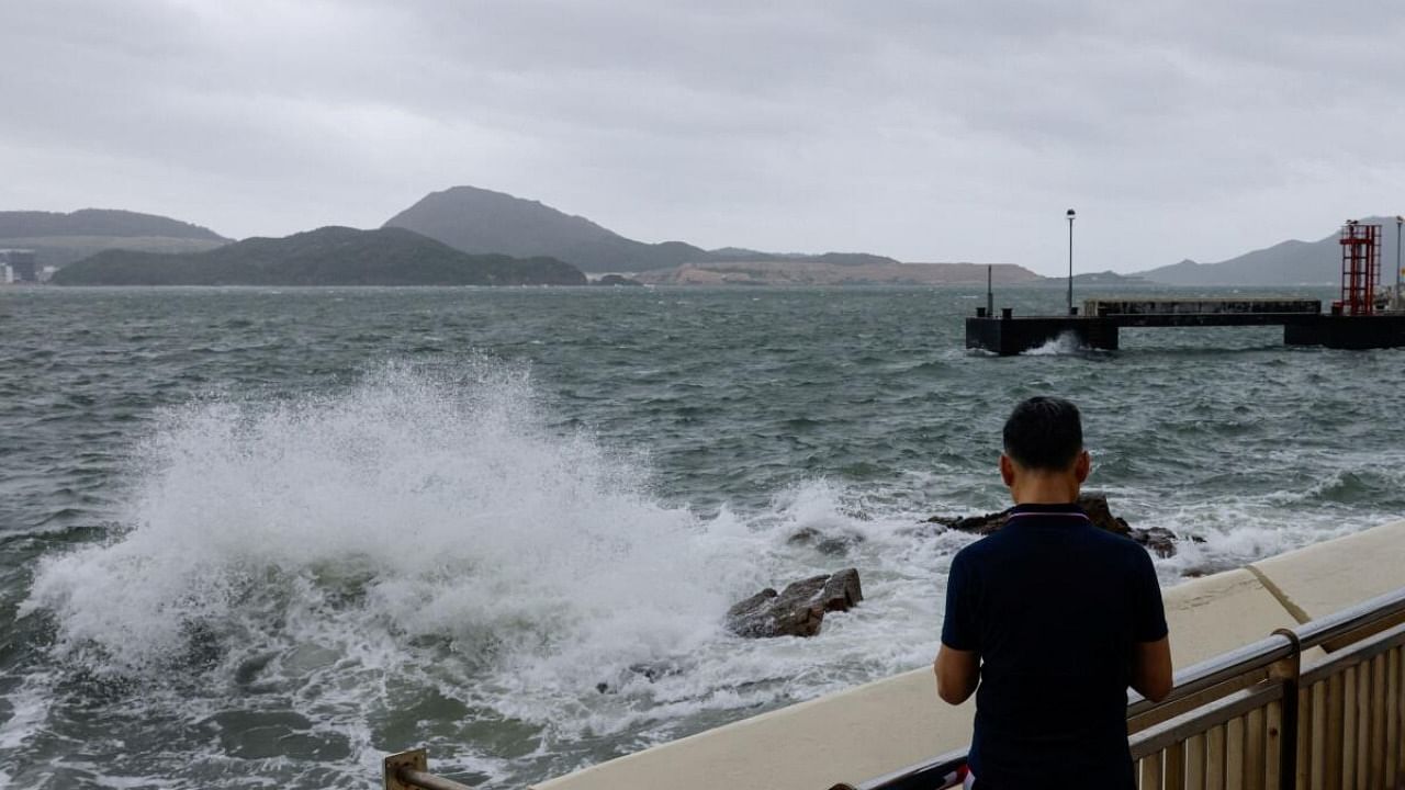 A man watches the waves at the seaside as Typhoon Talim approaches, in Hong Kong. Credit: Reuters Photo