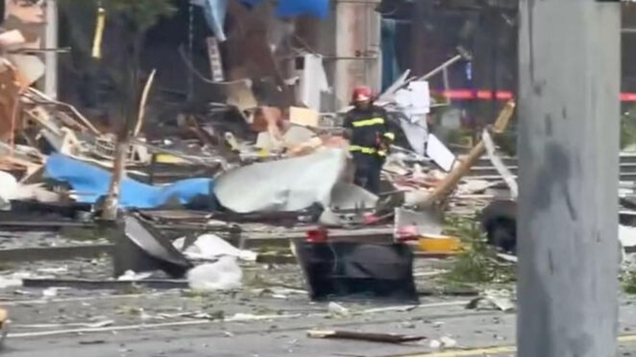A worker walks amid the debris from an explosion caused by cooking gas in Yancheng city, China in this screen grab from social media video released on July 17, 2023. Credit: Reuters Photo