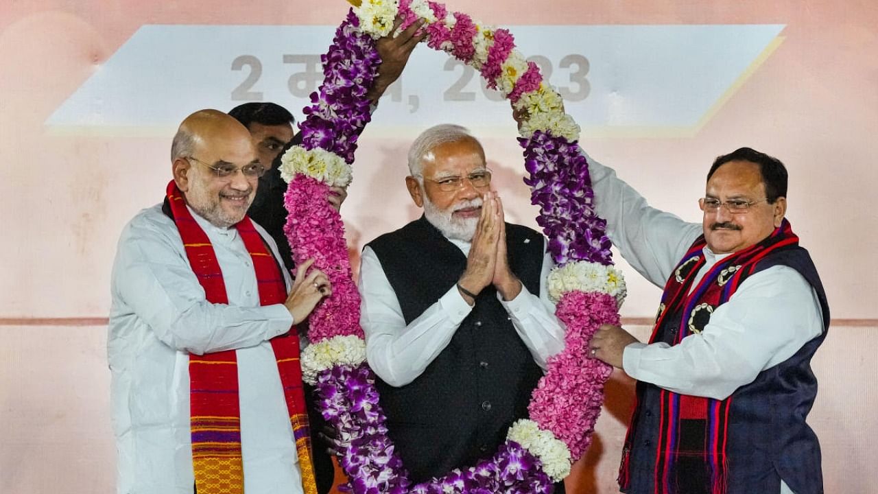 Prime Minister Narendra Modi being garlanded by BJP President J P Nadda and Union Minister Amit Shah during celebrations after the party's good performance in Nagaland, Tripura and Meghalaya Assembly polls, at the BJP HQ in New Delhi, Thursday, March 2, 2023. Credit: PTI Photo