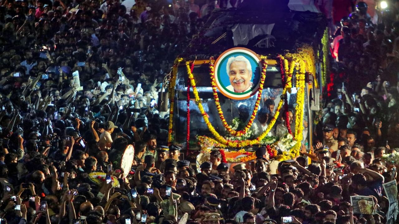 Crowd gather as the mortal remains of former Kerala Chief Minister Oommen Chandy being taken to Kottayam from Thiruvananthapuram, Wednesday, July 19, 2023. The funeral is scheduled to be held on Thursday at Puthuppally church. Credit: PTI Photo