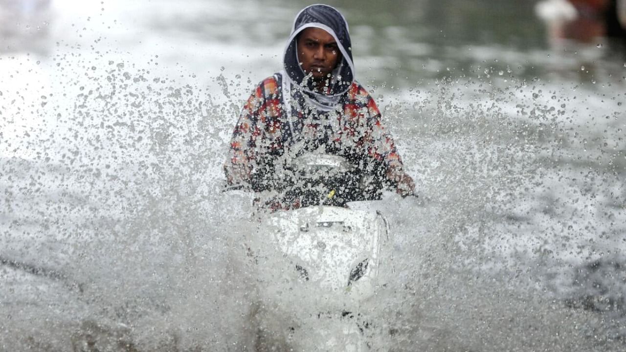 A person rides a scooter through a waterlogged road during monsoon rain showers in Mumbai, India, June 4, 2020. Credit: Reuters Photo