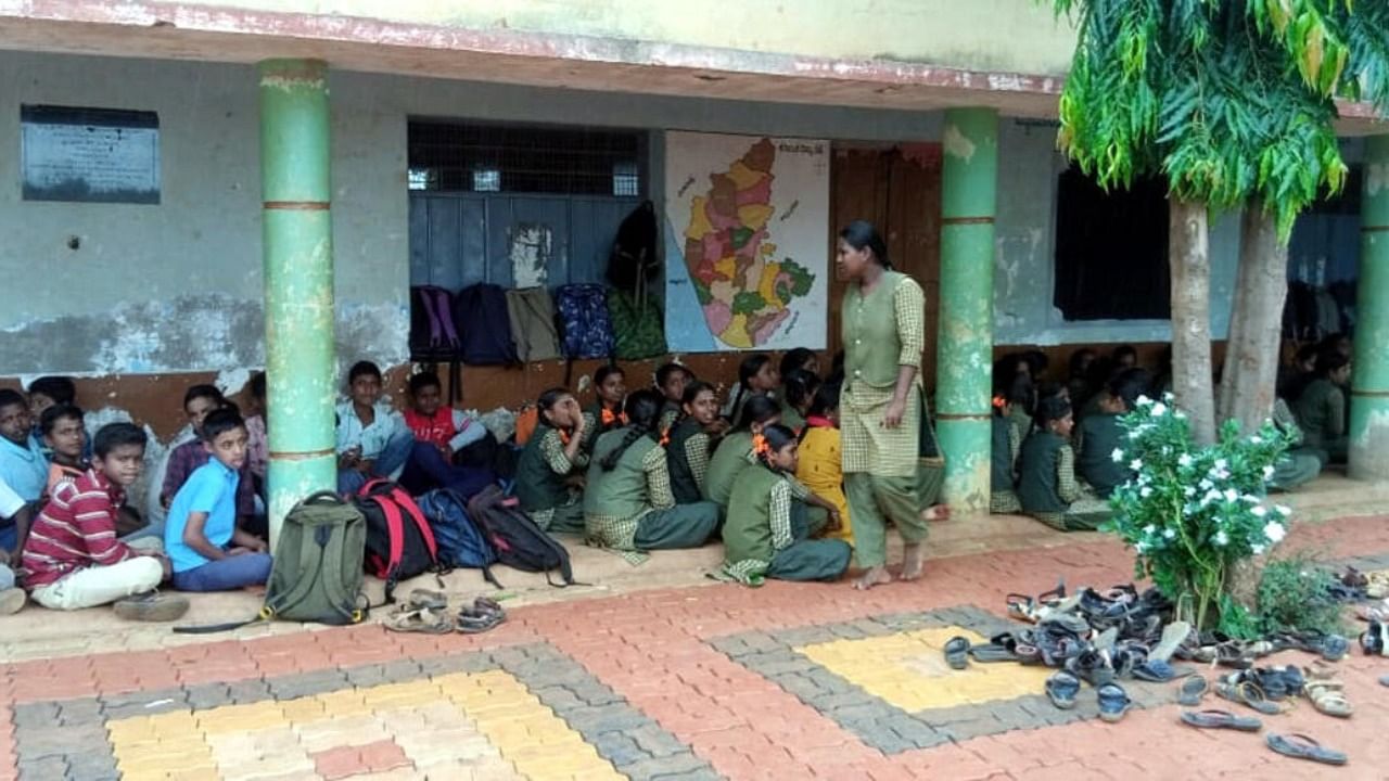 Students of Sangal Government High School in Ramdurg taluk stage a protest in front of the school on Monday. Credit: DH Photo