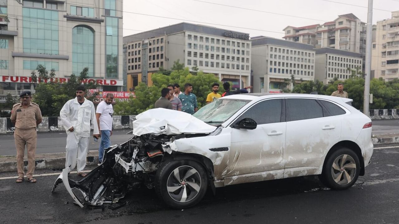 People stand near the wreckage of a vehicle after the accident in Ahmedabad. Credit: PTI Photo