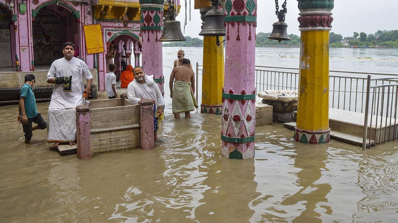 Monks at Vishram Ghat as floodwaters of the swollen Yamuna river enters the premises, in Mathura. Credit: PTI Photo