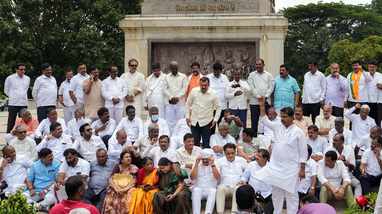 BJP MLAs stage a protest near the statue of Mahatma Gandhi against the suspension of 10 party MLAs, at Vidhana Soudha in Bengaluru, Thursday, July 20, 2023. Credit: PTI File Photo