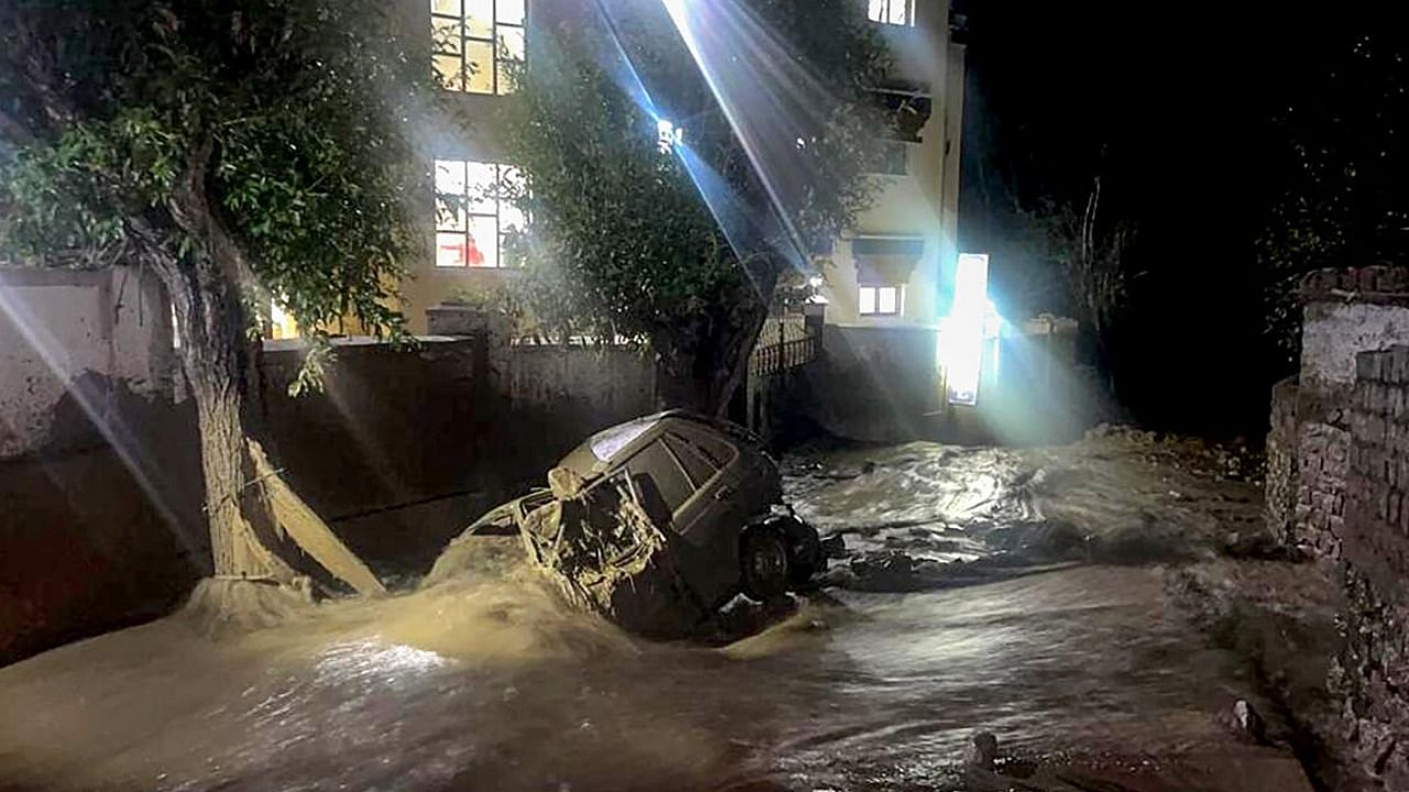  A damaged vehicle lies covered in silt and debris after cloudburst, in Leh district. Credit: PTI Photo