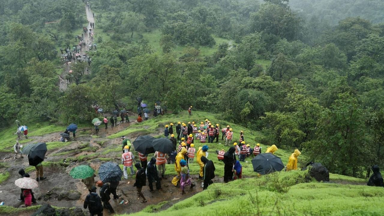 NDRF personnel and other volunteers climb up a mountain to reach the site of a landslide at a village in Raigad. Credit: Reuters File Photo