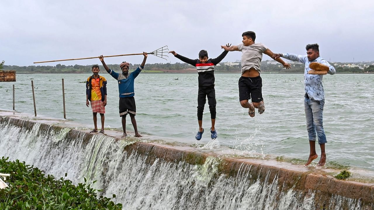 People at the Unkal Lake as it overflows following the heavy monsoon rains, in Hubballi, Saturday, July 22, 2023. Credit: PTI Photo