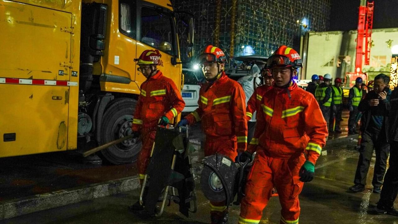 Firefighters at the site where the roof of a school gymnasium collapsed, in Qiqihar. Credit: Reuters Photo