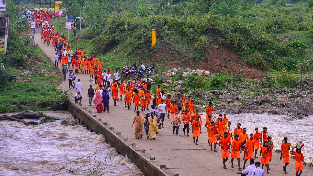 Lord Shiva devotees or 'Kanwariyas' carrying holy water from the Narmada river during their pilgrimage in the month of 'Shravan', in Jabalpur. Credit: PTI Photo