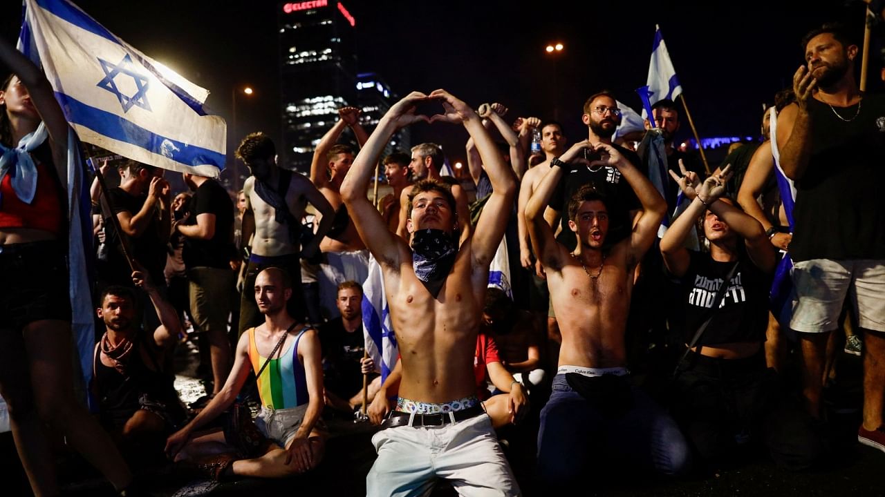 People make a heart-shaped gesture as protesters block Ayalon Highway during a demonstration following a parliament vote on a contested bill that limits Supreme Court powers to void some government decisions, in Tel Aviv, Israel July 25, 2023. Credit: Reuters Photo