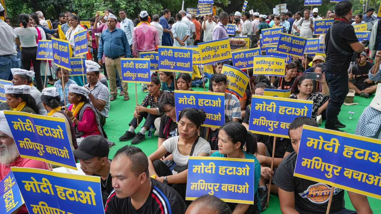 : AAP supporters holding placards take part in a protest over Manipur issue, in New Delhi. Credit: PTI Photo