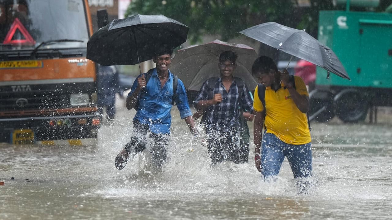 People wade through a waterlogged road amid monsoon rains, in Mumbai, Friday, July 21, 2023. Credit: PTI Photo