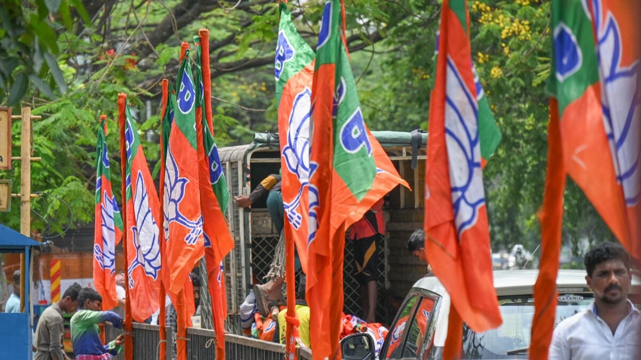 Workers tying BJP flags ahead of PM Modi's Bengaluru visit. Credit: DH File Photo