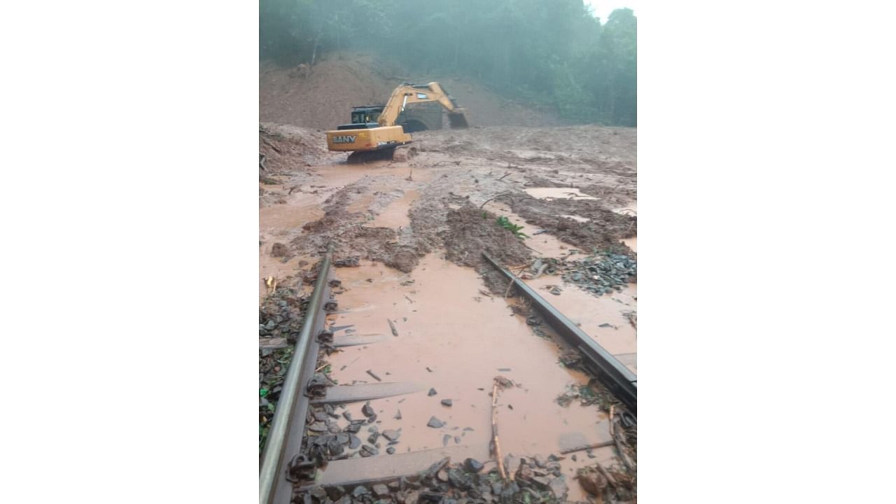 An earthmover is used to clear debris after a massive landslide on the railway tracks in the Braganza Ghat near the Karnataka-Goa border. Credit: DH Photo