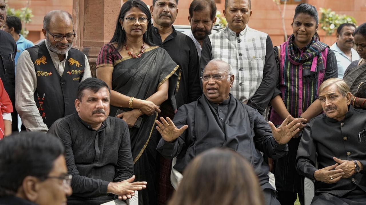 AAP MP Sanjay Singh with Leader of Opposition in Rajya Sabha Mallikarjun Kharge and other opposition MPs during a protest over his suspension from Rajya Sabha, at Parliament House complex amid the Monsoon session, in New Delhi. Credit: PTI Photo