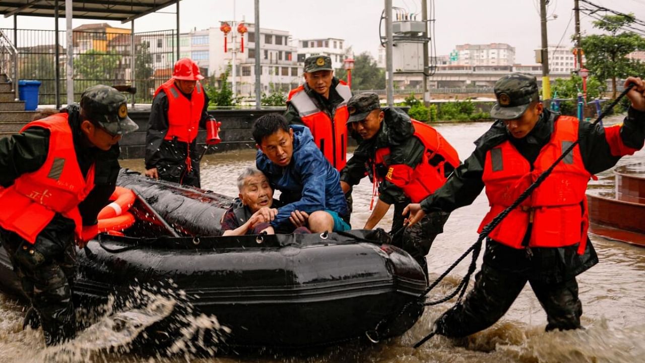 Paramilitary police officers evacuate residents stranded by floodwaters in Xincuo town of Fuqing city, after Typhoon Doksuri made landfall and brought heavy rainfall in Fuzhou, Fujian province, China July 29, 2023. Credit: Reuters Photo