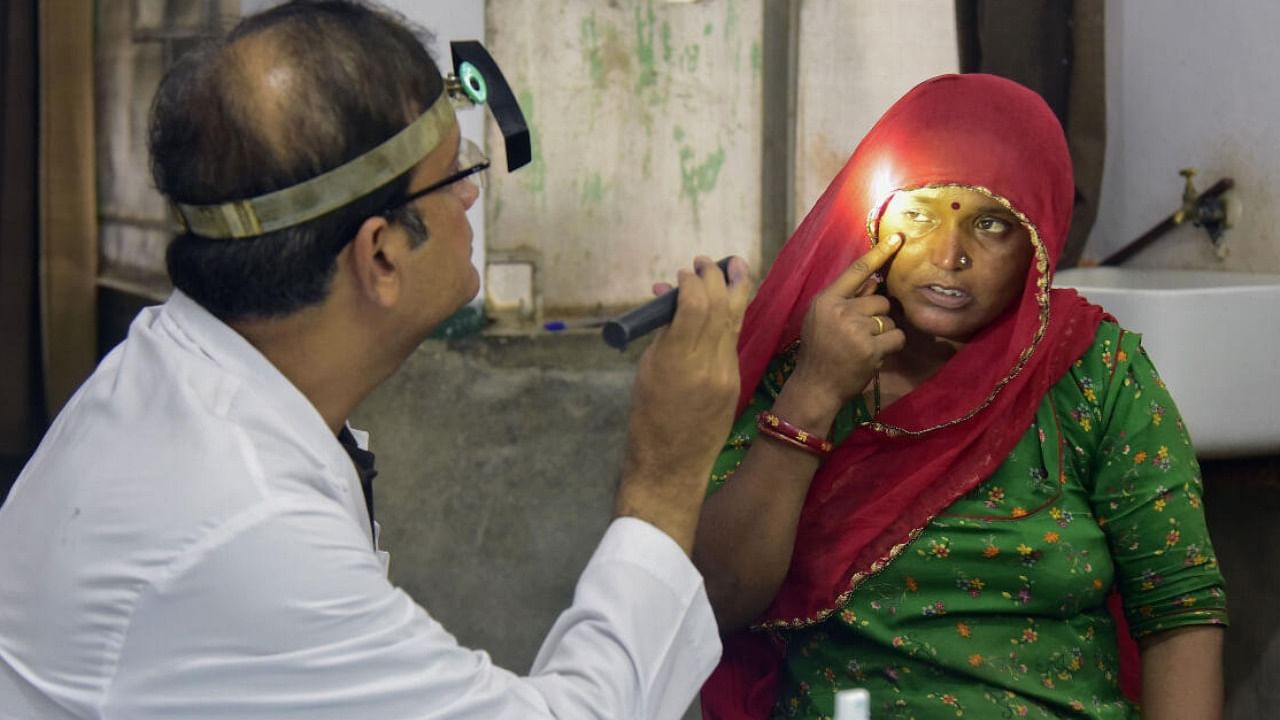 A doctor checks eyes of a woman at a hospital amid rise in Conjunctivitis. Credit: PTI File photo