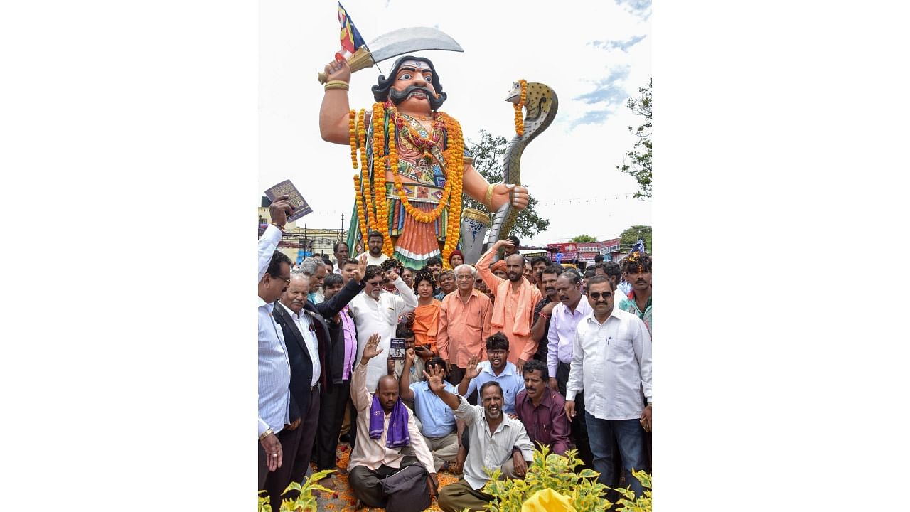 Members of Dalit Welfare Trust and University of Mysore Research Students Federation pay tributes to the statue of Mahishasura as part of Mahisha Dasara, atop the Chamundi Hill, in Mysuru, in 2017. Credit: DH File Photo