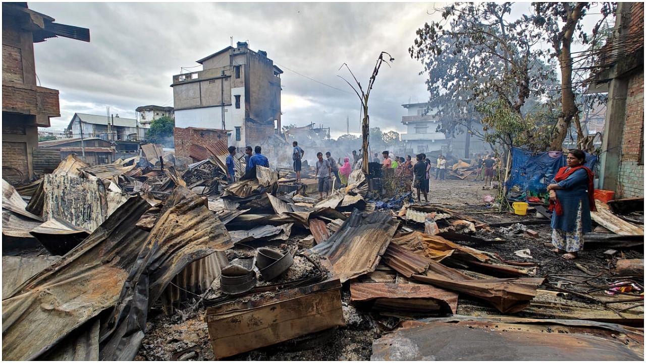 Imphal: Locals gather near Kuki-Zo community's houses which were burnt down by miscreants in the violence-hit Manipur, in imphal, Tuesday, Aug 1, 2023. The fire also engulfed more than a dozen houses of migrants from Bihar, Haryana, and Naga people. Credit: PTI Photo