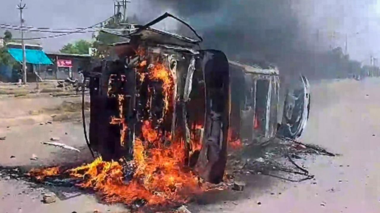 A vehicle set on fire by miscreants after clashes broke out during a religious procession, in Nuh, Monday, July 31, 2023. Credit: PTI Photo