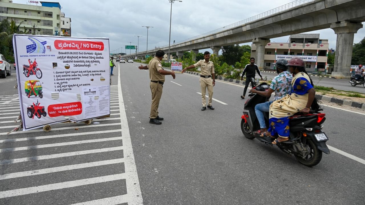 A board placed on the expressway near Anchepalya to create awareness about the ban on the entry of two-wheelers and autos. Credit: DH Photo/B H Shivakumar 