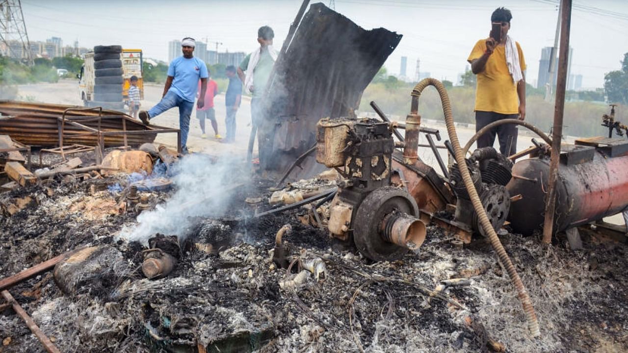 Locals look at burnt items at a shop which was set ablaze by miscreants in a fresh case of communal violence after Monday's attack on a VHP procession in adjoining Nuh district, in Gurugram, Wednesday, Aug. 2, 2023. Credit: PTI Photo