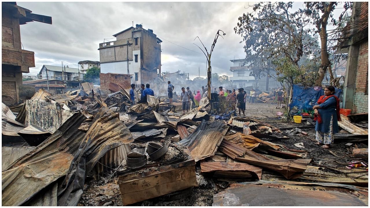 Imphal: Locals gather near Kuki-Zo community's houses which were burnt down by miscreants in the violence-hit Manipur, in imphal, Tuesday, Aug 1, 2023. The fire also engulfed more than a dozen houses of migrants from Bihar, Haryana, and Naga people. Credit: PTI Photo