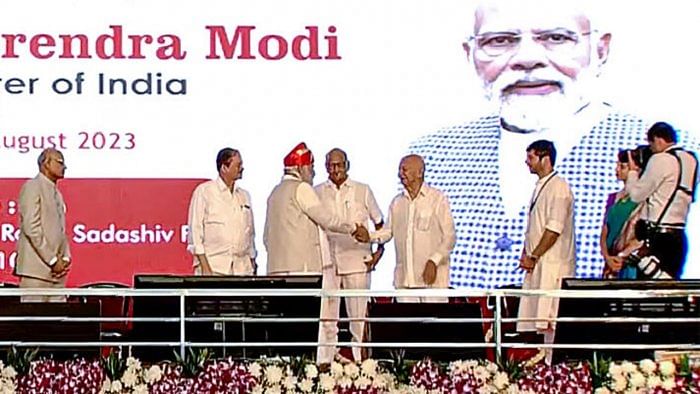 Prime Minister Narendra Modi being greeted by Congress leader Sushilkumar Shinde as Nationalist Congress Party (NCP) President Sharad Pawar looks on after Modi was conferred with Lokmanya Tilak National Award, in Pune, Tuesday, Aug. 1, 2023. Credit: PTI Photo