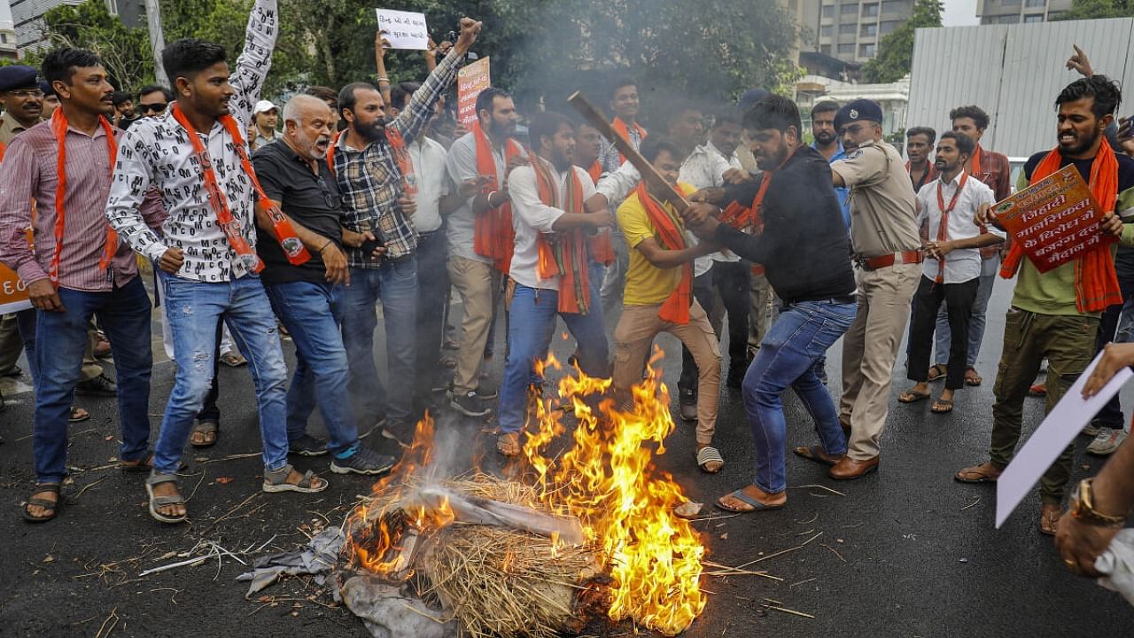 <div class="paragraphs"><p>Vishva Hindu Parishad (VHP) and Bajrang Dal activists burn an effigy during a protest against the violence in Haryana's Nuh district, in Ahmedabad, Wednesday, Aug. 2, 2023. </p></div>