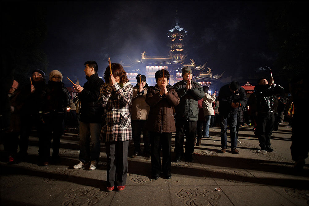 Worshippers burn joss sticks to pay their first visit of the "Year of  the Dragon" at Longhua Temple in Shanghai, China on early Monday Jan.  23, 2012. Chinese celebrate the Lunar New Year, also known as the Spring  Festival in China, on Jan. 23, 201...