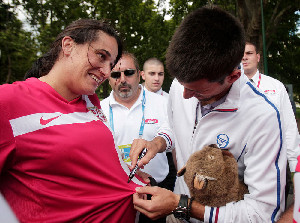 Australian Open men's singles champion Serbia's Novak Djokovic signs his  autograph onto the shirt of a fan at a park in central Melbourne,  Australia, Monday, Jan. 30, 2012.  Djokovic defeated Spain's Rafael  Nadal in five hours and 53 minutes to wi...